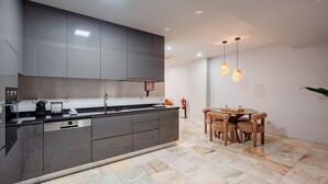 Una cocina moderna con una isla central, electrodomésticos integrados y un comedor con mesa y sillas.