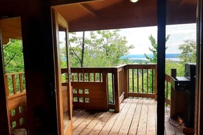 A wooden deck with a view of a lake and trees. - TRACKERS CABIN, VERY PRIVATE, HIKE IN, NO NEIGHBORS, PET FRIENDLY  (Golden Lake)