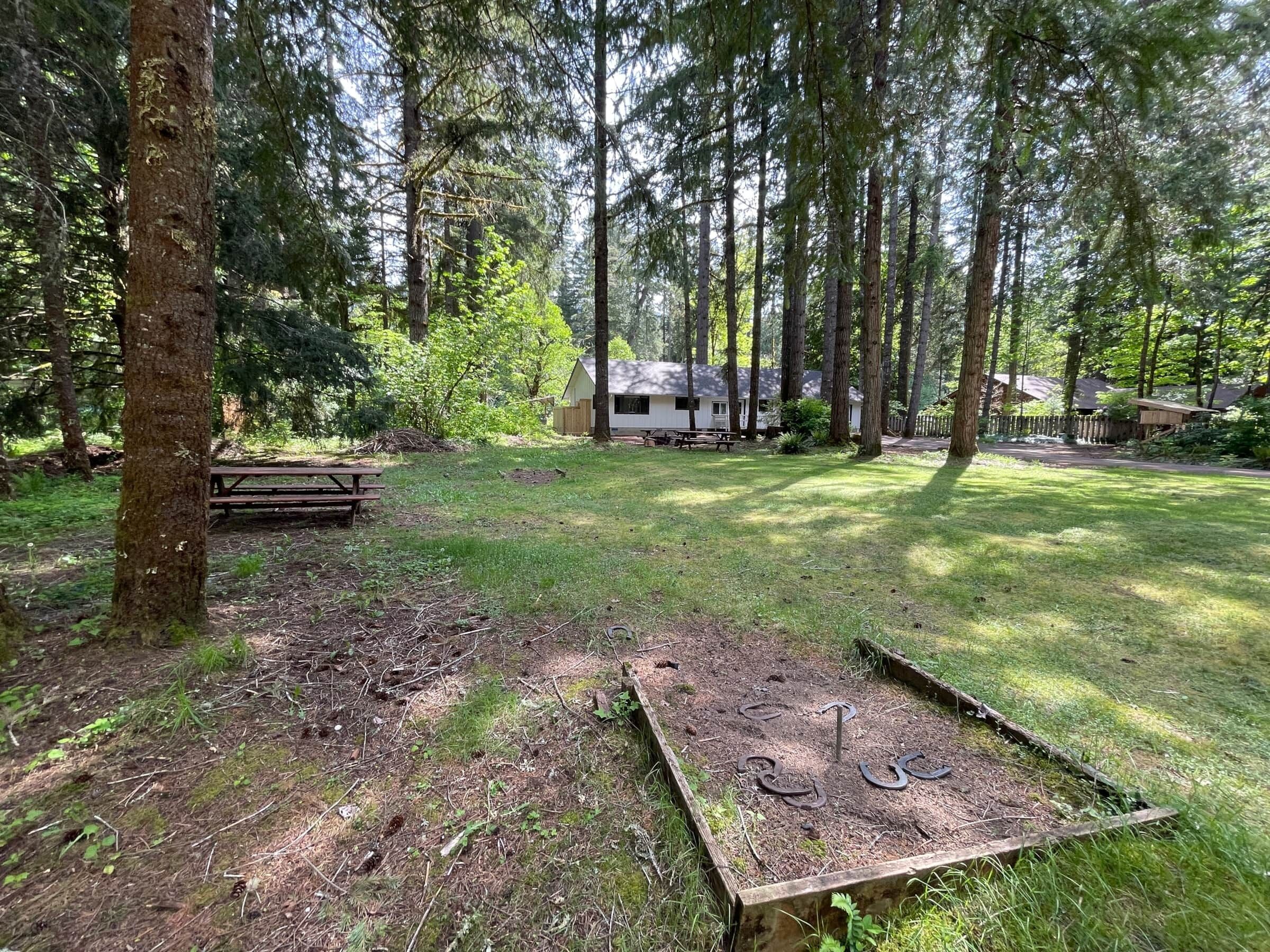 Ett skogsområde med ett picknickbord och en lekställning i trä.