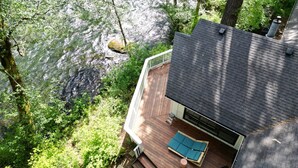 Una terraza con vista a un río y follaje circundante.
