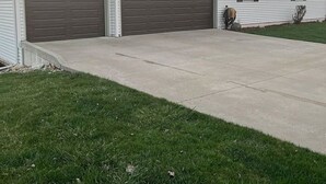 A single-story house with a garage, a driveway, and a lawn.