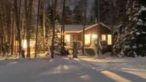 A snow-covered landscape with a house in the background.