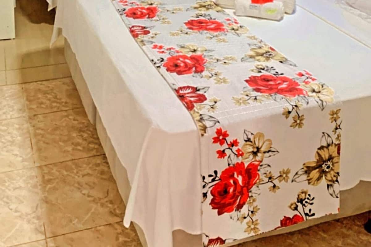 A hotel room with two beds, floral bedspreads, and two seahorse wall decorations.