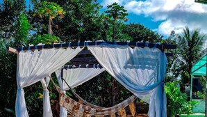 A wooden deck with a hammock and a canopy structure. - Pousada Visual do Porto (Fernando de Noronha)
