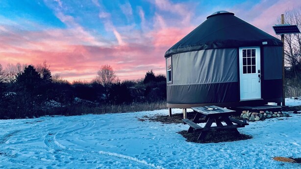 Schneebedeckte Landschaft mit einem Jurten-ähnlichen Zeltdach.