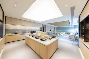 Una cocina moderna con una isla central, electrodomésticos integrados y un comedor con asientos.