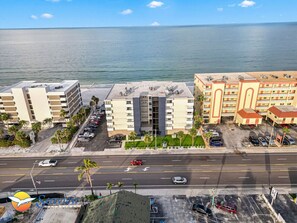 A coastal hotel with multiple buildings, a parking lot, and a view of the ocean. - Spacious Beachfront Corner Condo in Madeira Beach| Gulf-Front|Pool & Hot-tub (Madeira Beach)