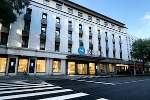 Un hôtel moderne doté d’une entrée imposante, de plusieurs étages et offrant une vue dégagée sur le ciel.