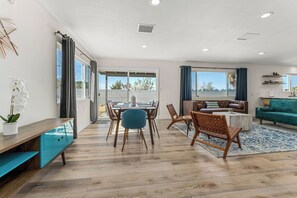 A modern living room with a dining area, a sofa, and a coffee table.