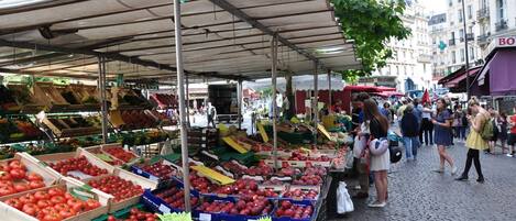 An outdoor market with various stalls selling fresh produce.