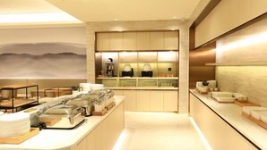 Un hall d’hôtel moderne comprenant un comptoir d’accueil, un espace salon et un écran fixé au mur.