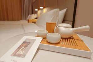 A neatly arranged tea set on a tray with a book beside it, placed on a bed in a modern hotel room. - JI Hotel (Beijing Asian Games Village Bird's Nest) (Beijing)