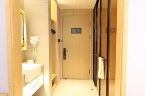 A hotel hallway with a wooden door, a white sink, and a mirror. - JI Hotel (Beijing Asian Games Village Bird's Nest) (Beijing)