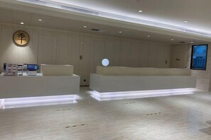 A reception area with a modern design, featuring a reception desk, a digital display, and a wall-mounted sign. - JI Hotel (Beijing Asian Games Village Bird's Nest) (Beijing)