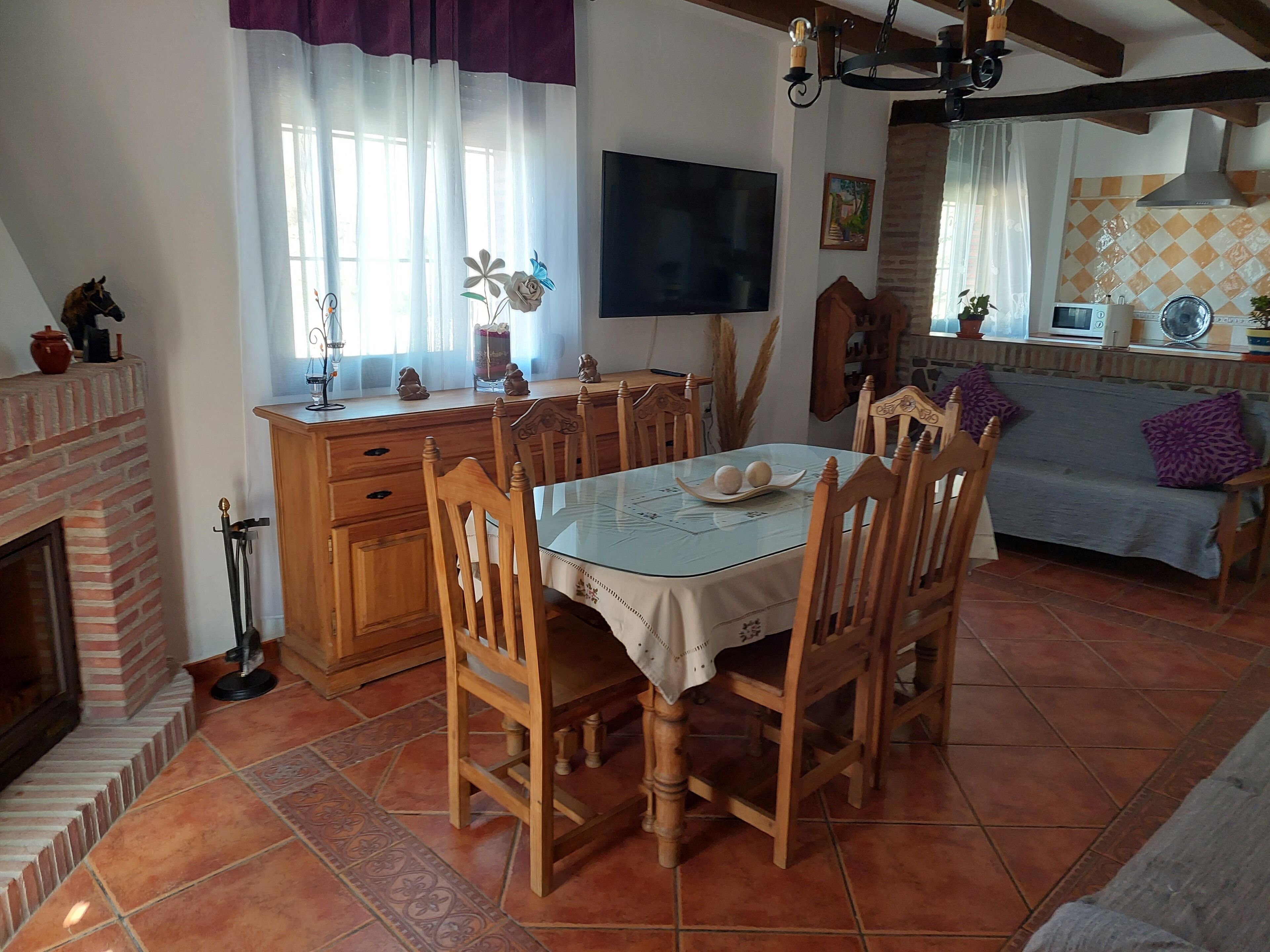 A dining area with a wooden table, chairs, and a fireplace.