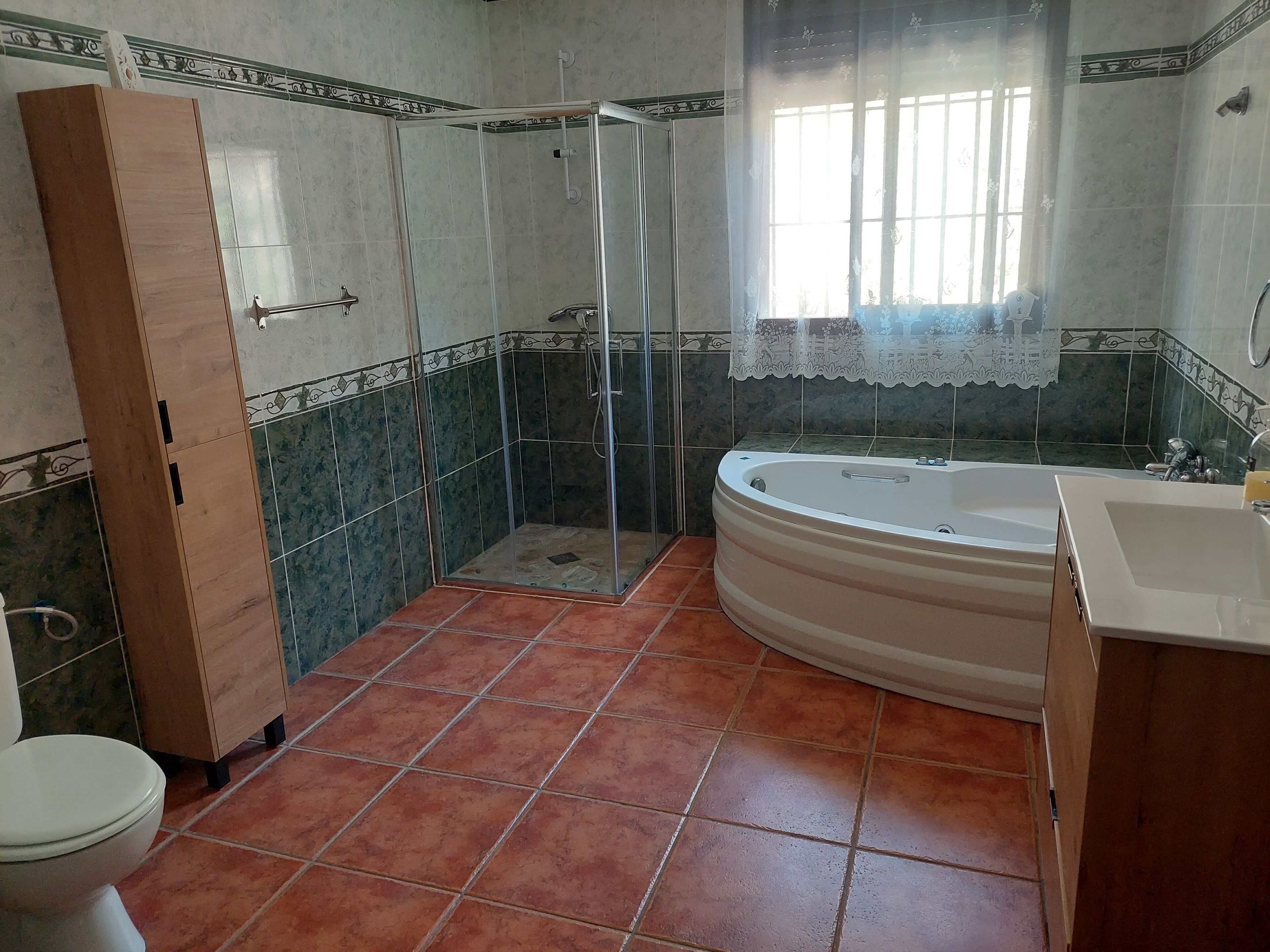 A bathroom with a shower, a bathtub, a toilet, and a sink.