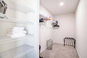 A laundry room with white shelves, a radiator, and a hanging rack. - 4BR Casa Grande Home | Fast WiFi, Grill + Sleeps 8 (Casa Grande)