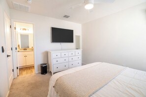 A bedroom with a bed, a dresser, a mirror, and a television on the wall. - 4BR Casa Grande Home | Fast WiFi, Grill + Sleeps 8 (Casa Grande)