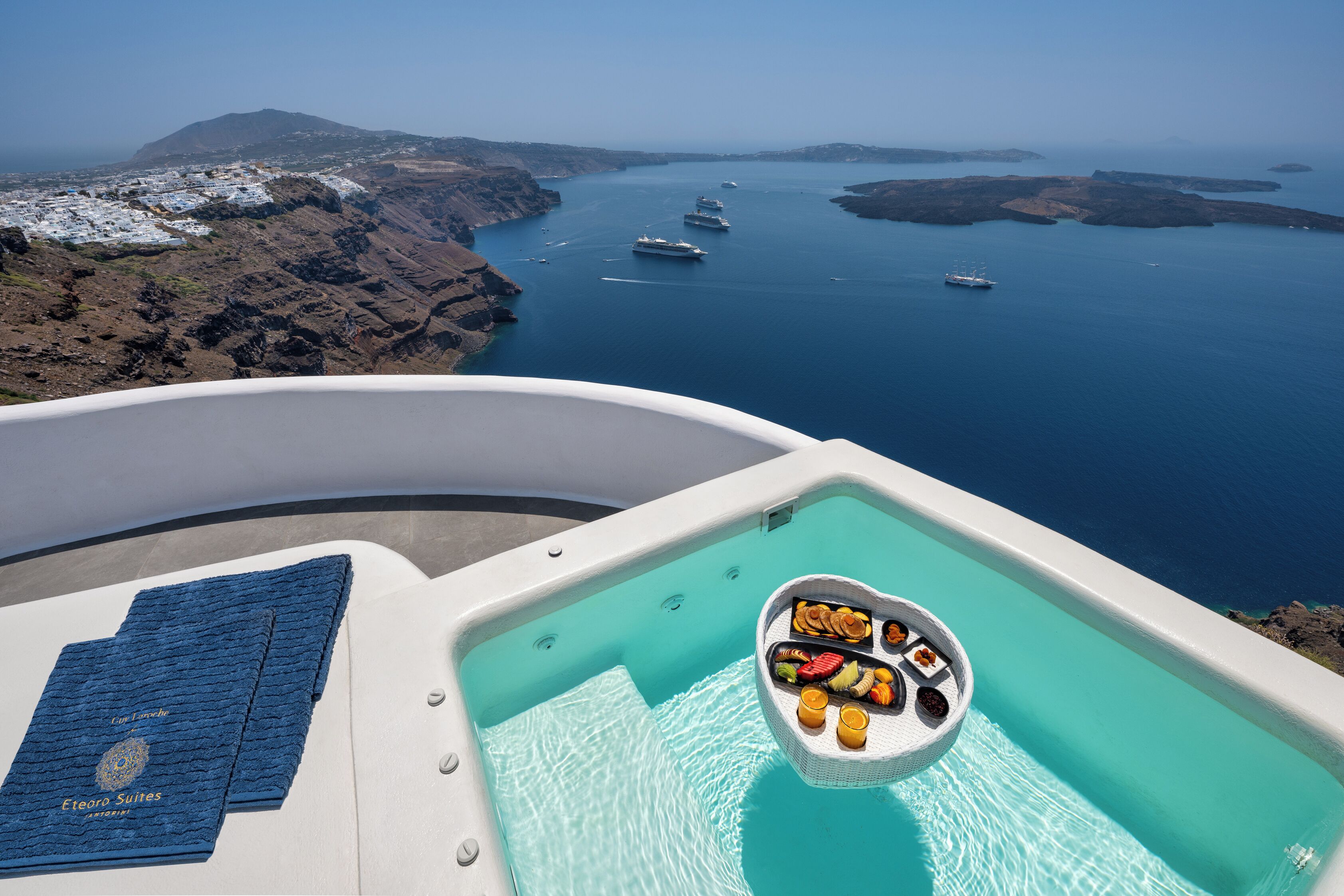 Un jacuzzi con vista al mar y barcos, un menú y una toalla.