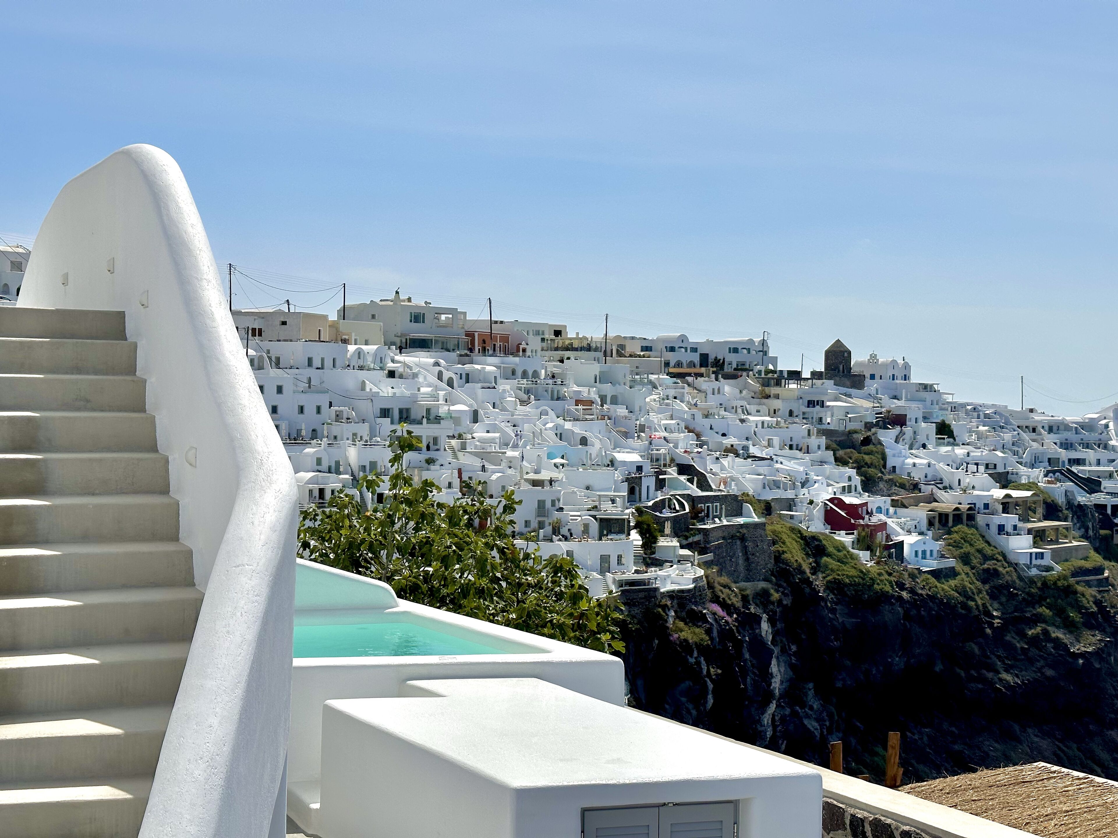 Un edificio blanco con una escalera que lleva a una piscina.