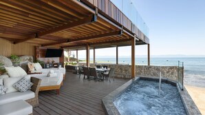A covered outdoor area with a hot tub, seating, and a view of the sea. - Secrets Bahia Mita Surf & Spa (Punta de Mita)