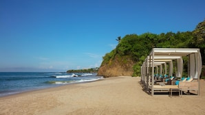 A beach with a row of sunbeds under a canopy, overlooking the ocean. - Secrets Bahia Mita Surf & Spa (Punta de Mita)