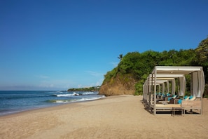 Na praia, espreguiçadeiras, toalhas de praia 