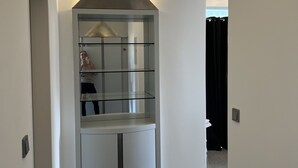 A modern, minimalist bathroom with a glass shower enclosure, a built-in sink, and a towel rack.