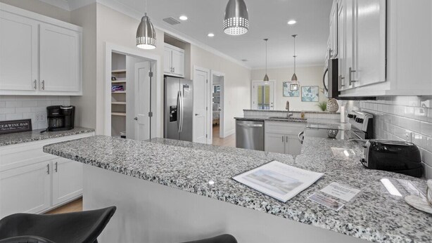 A modern kitchen with granite countertops, stainless steel appliances, and pendant lighting. - Wait' N Sea - Vacation Home Steinhatchee Florida (Steinhatchee)