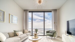 Una sala de estar moderna con un ventanal grande, un sofá, una mesa de centro y un televisor.