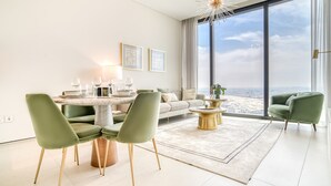Una sala de estar moderna con comedor, ventanas amplias y vistas a la ciudad.
