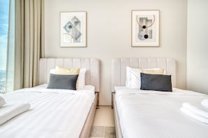 A hotel room with two beds, a city view, and framed artwork on the walls. - Cityscape and Majestic Retreat at Address JBR (Dubai)