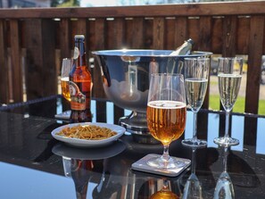 Une table avec une bouteille de bière, un bol et des verres de bière.