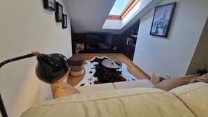 Uma sala de estar moderna com claraboia, um sofá, uma mesa de centro e um tapete de couro de vaca.