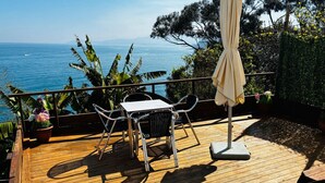 Um deck de madeira com mesa e cadeiras, com vista para um corpo d'água.