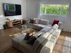 Relax in this stylish living room with a large L-shaped sofa, flat-screen TV, and entertainment unit.