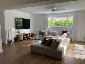 Relax in this stylish living room with a large sofa, flat-screen TV, and entertainment unit.