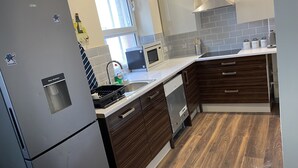 Eine moderne Küche mit Kühlschrank, Mikrowelle, Spüle und Holzschränken.