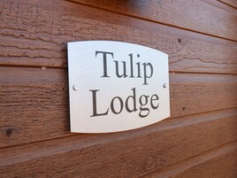 Un letrero de madera con el texto 'Tulip Lodge'.