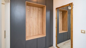 A modern room with a large wardrobe, a mirror, and a wooden bench. - Apartment Koko - Two Bedroom with Terrace (Dubrovnik)