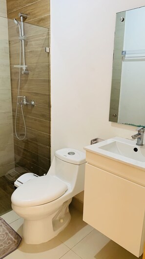 A bathroom with a toilet, a shower, and a sink. - Apartamento torre ll (Santo Domingo Este)