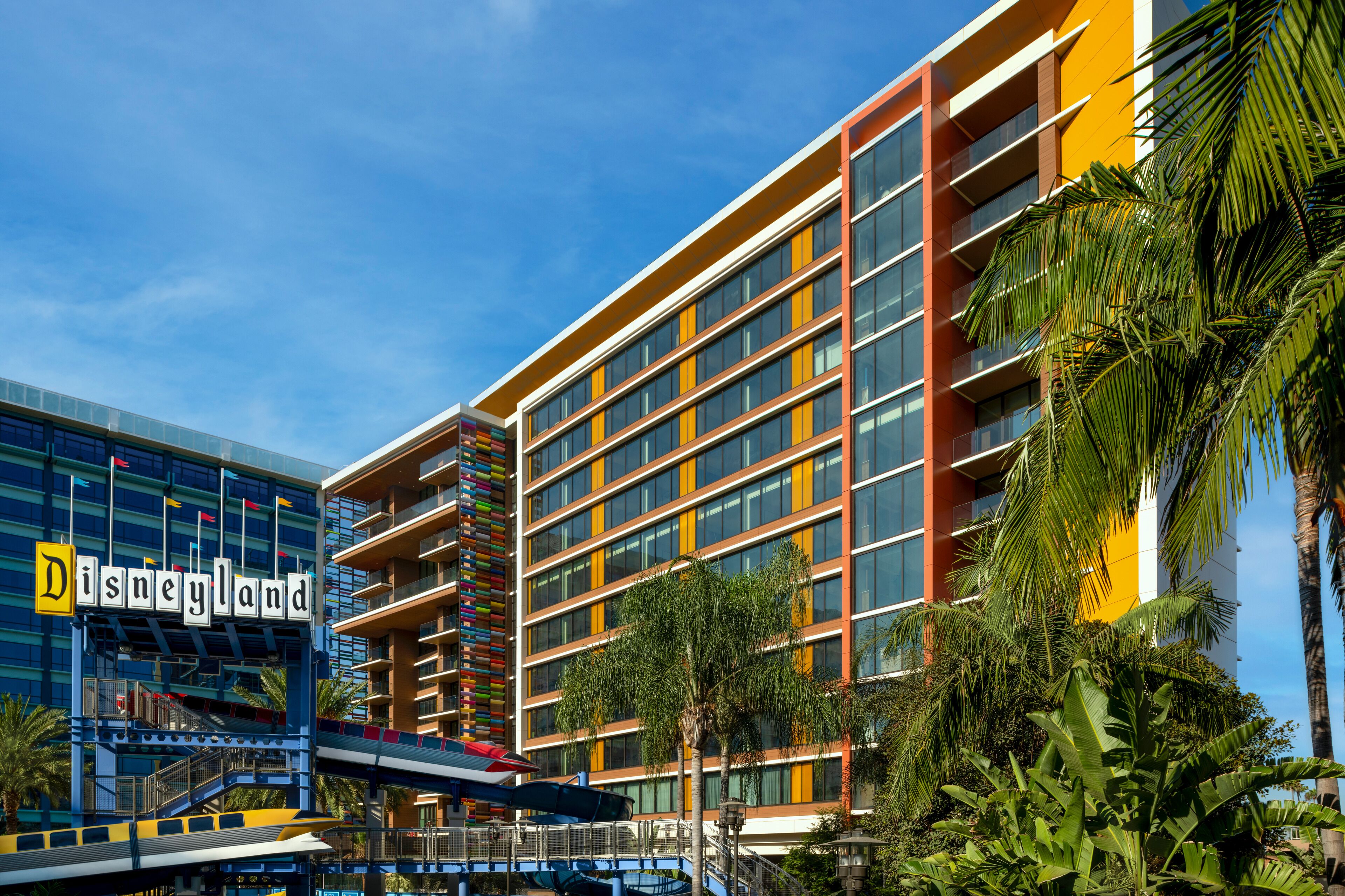 A multi-story building with a Disney sign, balconies, and palm trees.
