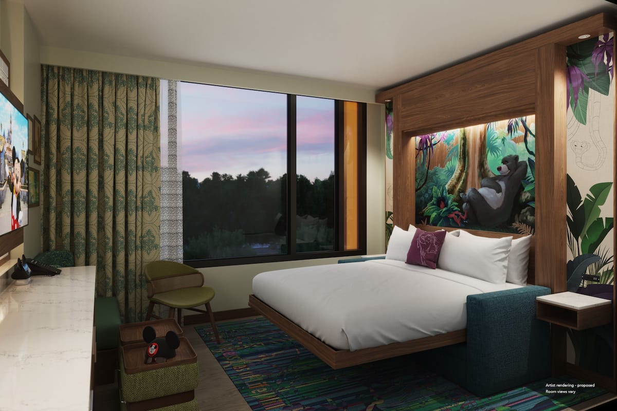 Ein modernes Hotelzimmer mit einem großen Bett, Blick ins Freie, einer kleinen Sitzecke und einem Wandbild.