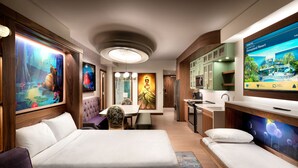 Een moderne hotelkamer met een groot bed, een bank, een eethoek en een keuken.