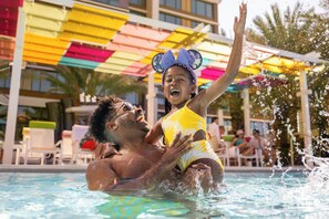 Una piscina al aire libre, camas de piscina con cargo, sombrillas