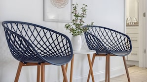 Two modern chairs with a geometric design, a white vase with a plant, and a framed artwork on the wall. - Steps to Beach! |Sleeps 11!| Summer Ready! (Panama City)