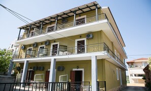 Un immeuble à deux étages doté de balcons, de climatiseurs et d’une entrée sécurisée par un portail.