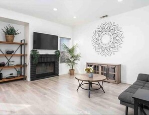 Cozy up by the fireplace in this stylish living room, featuring a flat-screen TV and comfortable seating area.