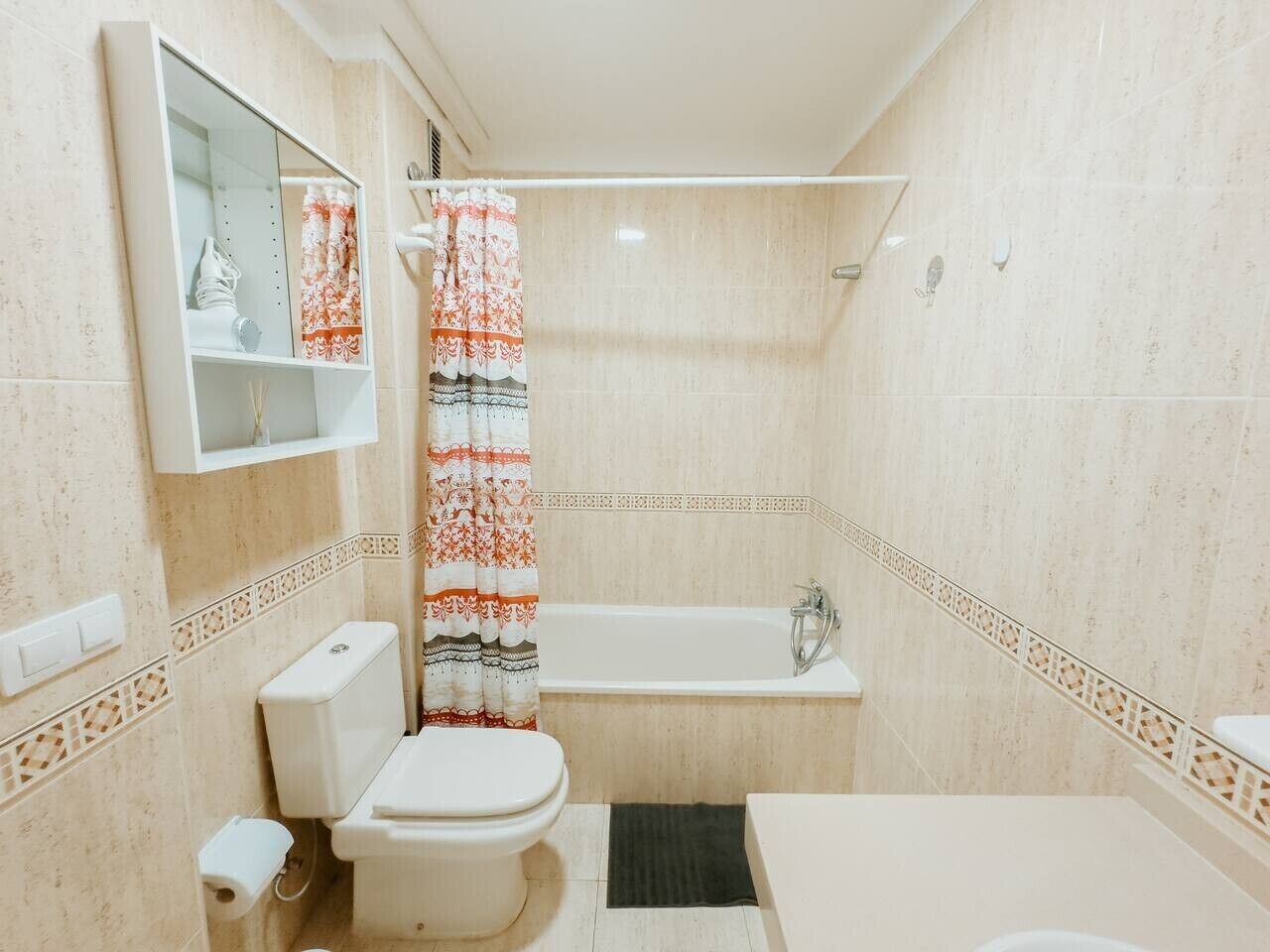 Une salle de bain avec des toilettes, un lavabo et une baignoire.