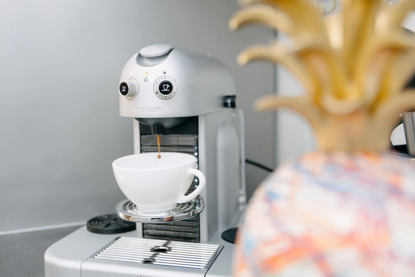 En Nespresso-kaffemaskine serverer kaffe i en kop.